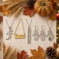Personalized name and initial necklaces arranged with autumn pumpkins and leaves