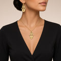 Woman wearing a gold personalized Hamsa necklace and matching Hamsa initial earring